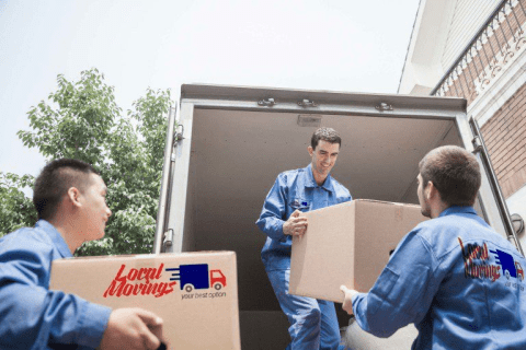 Three men loading boxes into a moving truck.