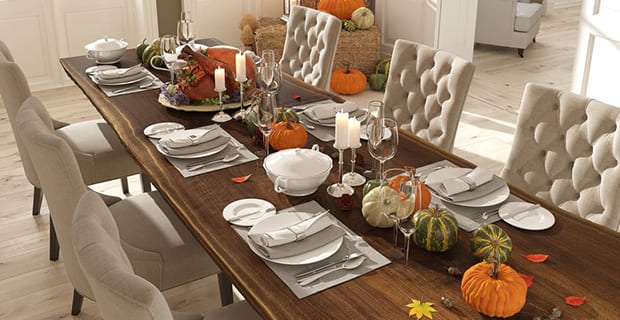 A table with plates and pumpkins.